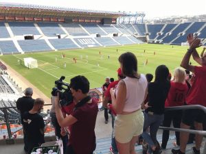 Stadium Scene with a woman filming inside the section